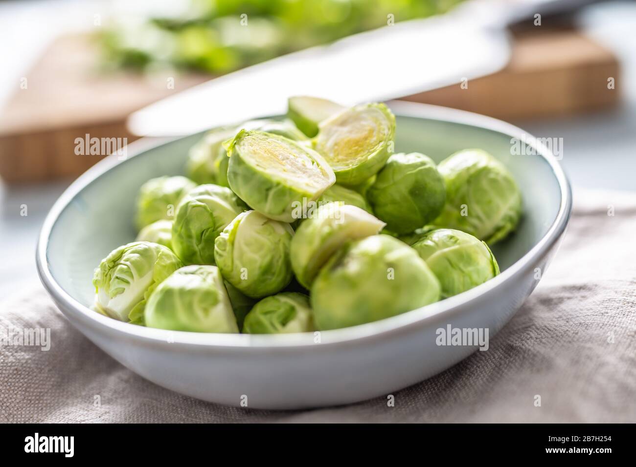 Fresh brusseles sprouts in bowl on kitchen table Stock Photo
