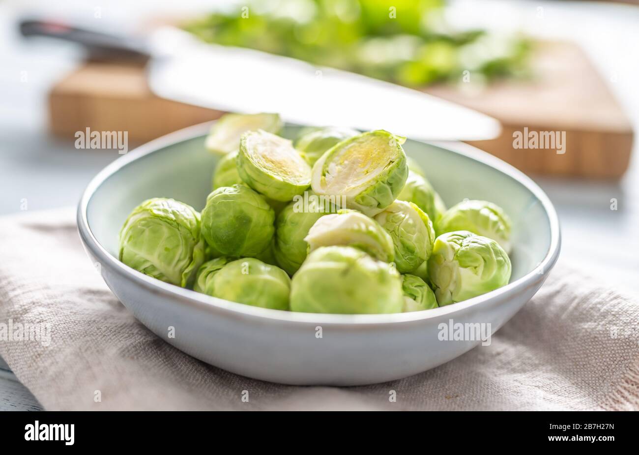 Fresh brusseles sprouts in bowl on kitchen table Stock Photo
