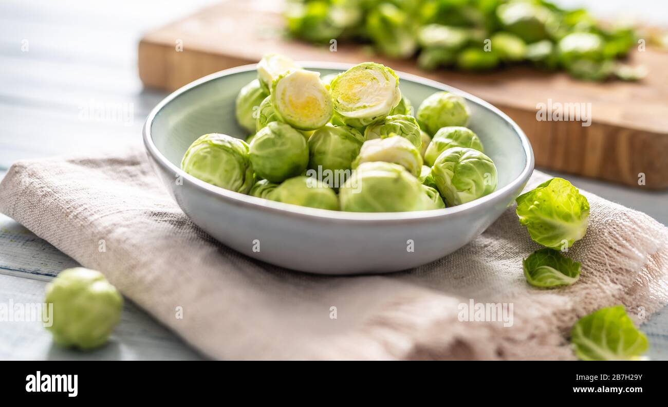 Fresh brusseles sprouts in bowl on kitchen table Stock Photo