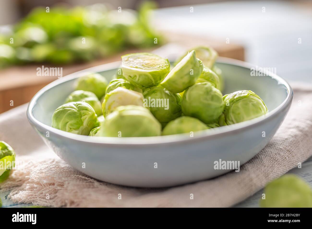Fresh brusseles sprouts in bowl on kitchen table Stock Photo