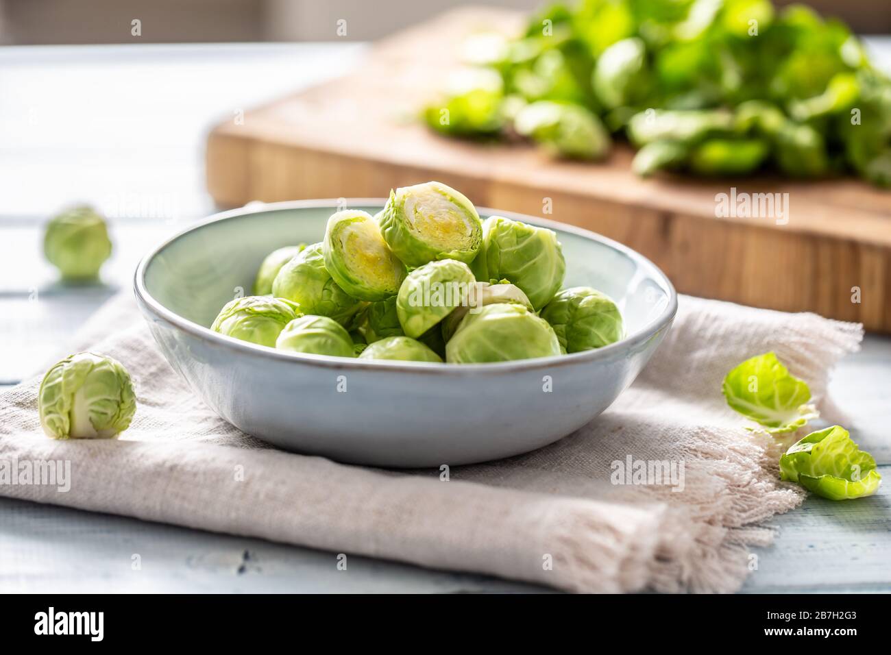 Fresh brusseles sprouts in bowl on kitchen table Stock Photo