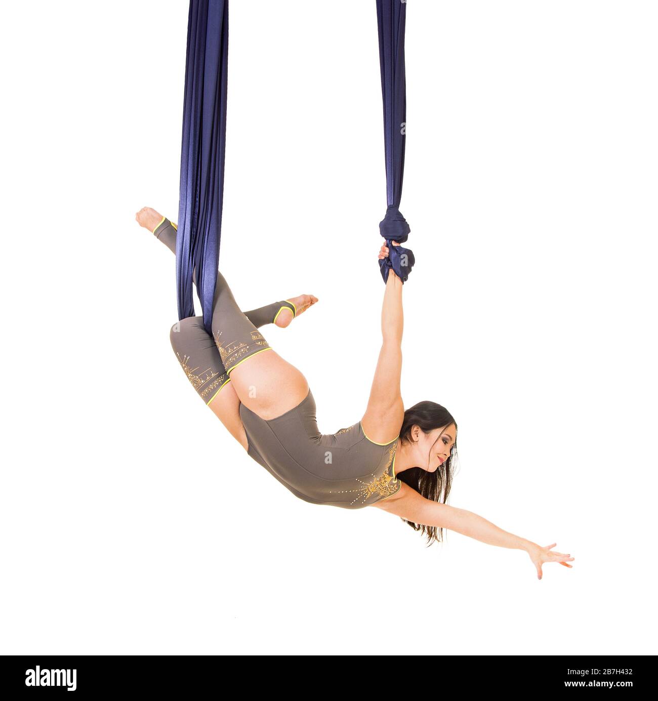 Young, smiling acrobat, with long hair, in a gray suit and leggings ...