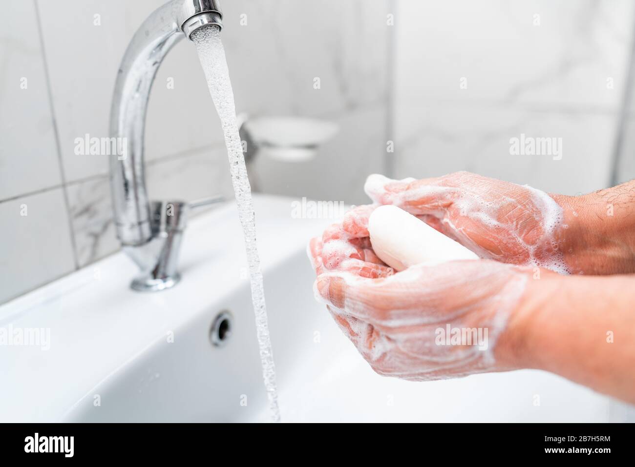 Personal hygiene, cleaning hands with soap often on faucet to protect from virus Stock Photo