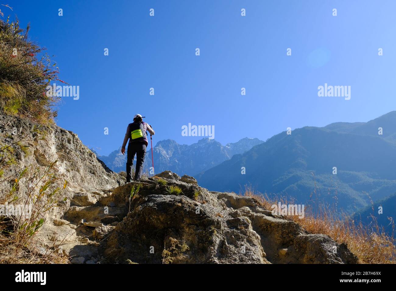 Trekker hiking with trekking pole on the mountain in Yunnan, China. Stock Photo