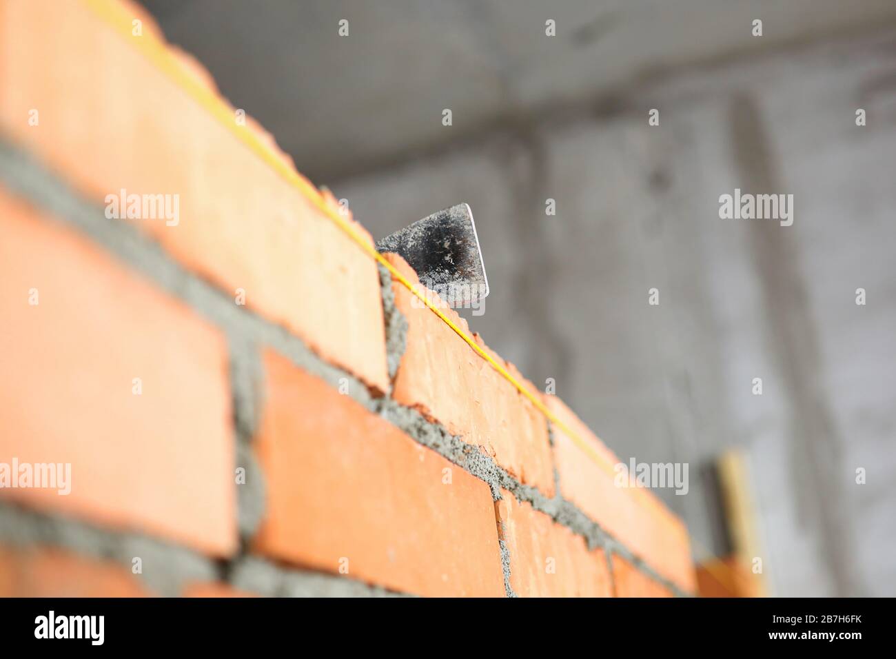 Mallet lying on top of brick wall as building and renovation Stock Photo