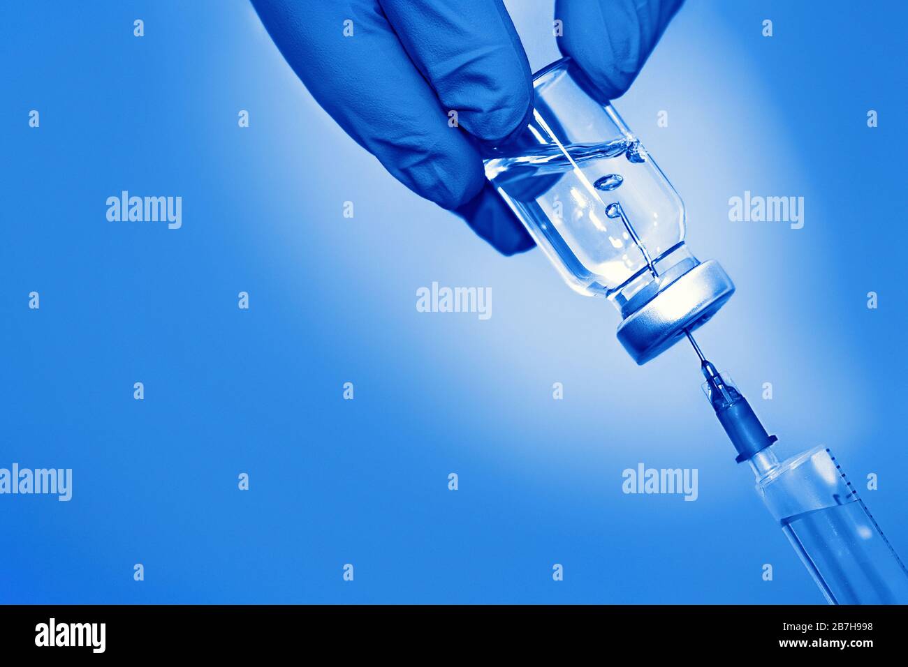 Vaccine in a bottle with a syringe on a blue background.The concept of ...