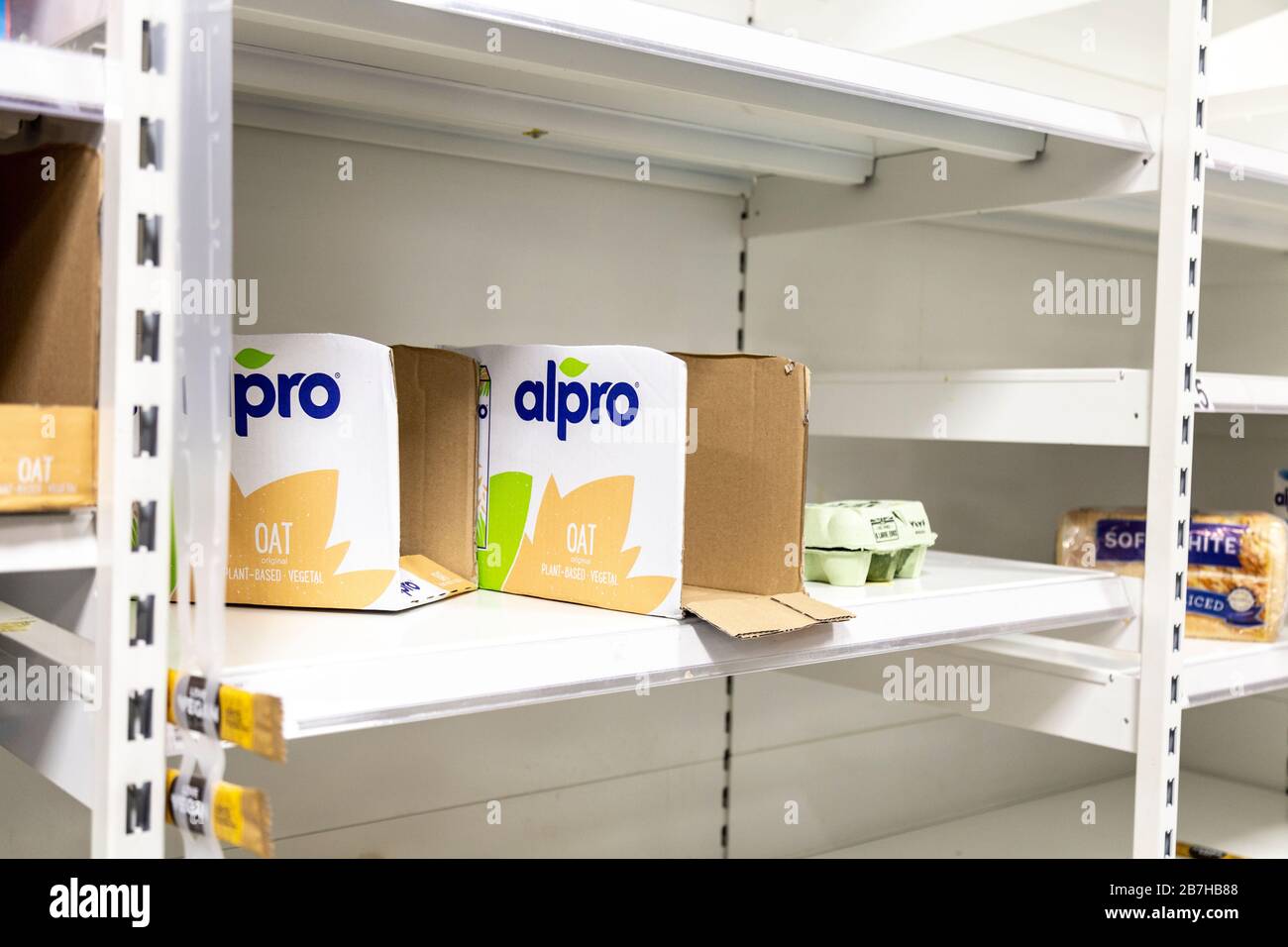 16 March 2020 - London, UK - Empty supermarket shelves at ASDA Stepney as people panic buy to stock up during the Coronavirus outbreak, empty boxes of longlife oat milk Stock Photo