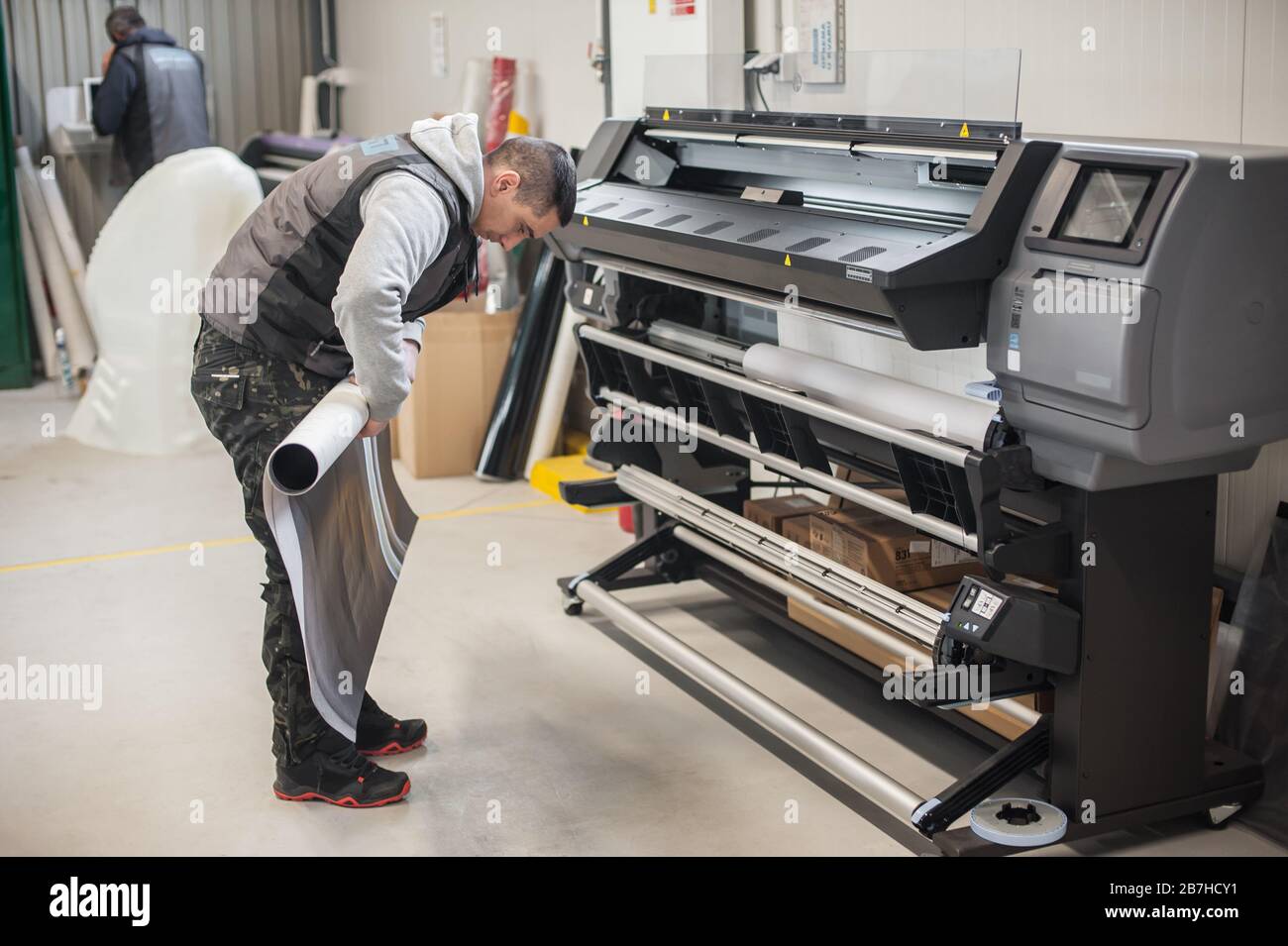 Technician worker operator changes the paper roll on large premium