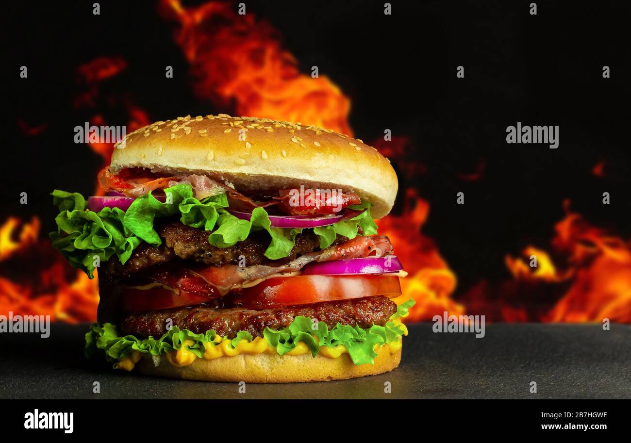 Delicious tasty home made hamburger with meat and cheese and black textured background. Concept fast food. Stock Photo