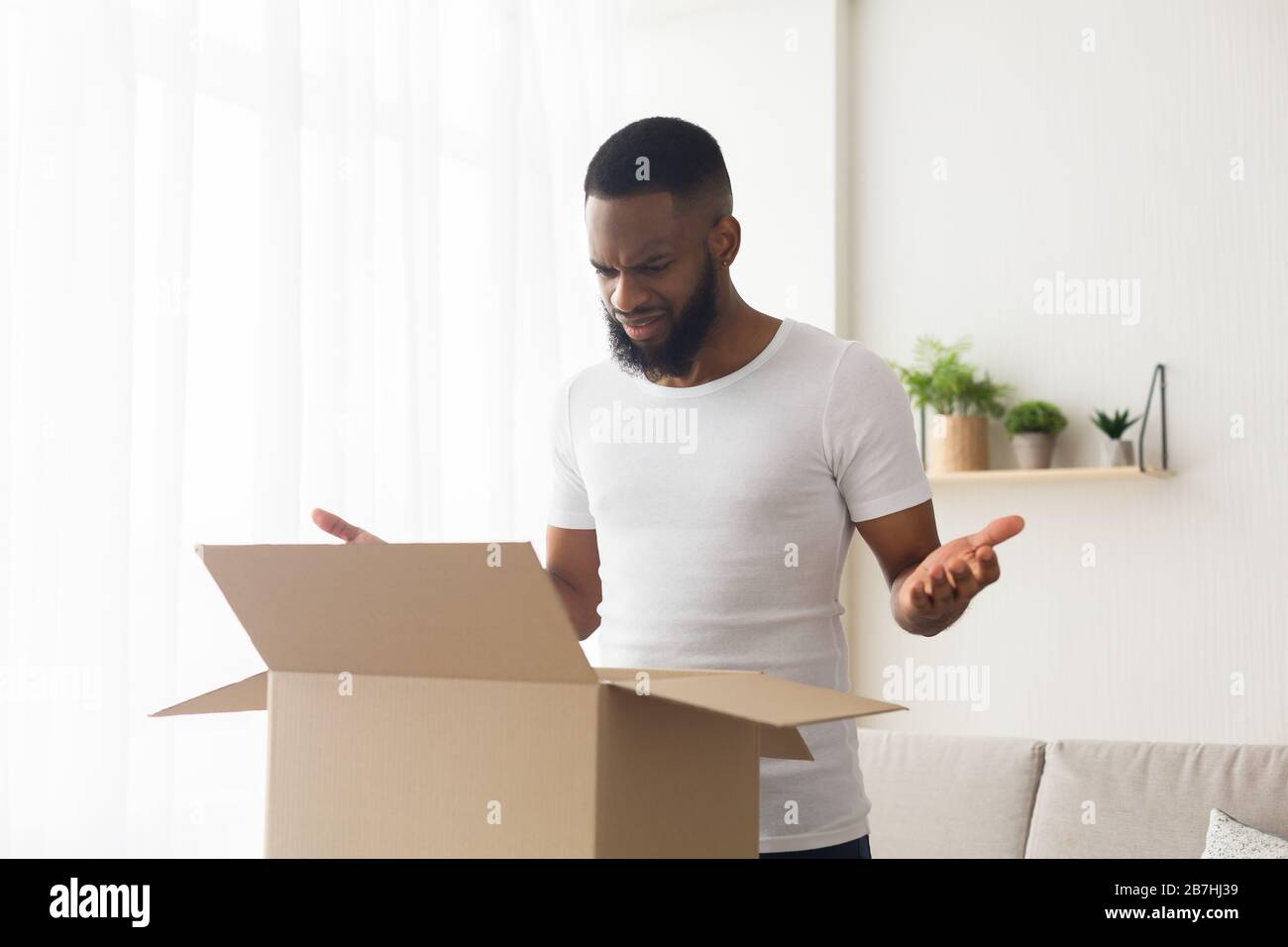African American buyer opened delivery and unhappy Stock Photo