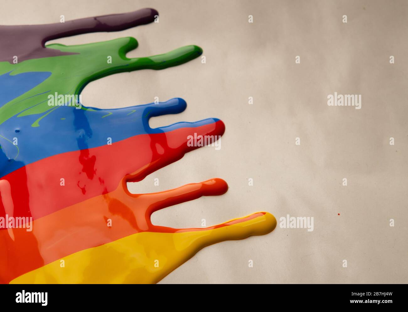 Colored paint stains dripping on gray background Stock Photo
