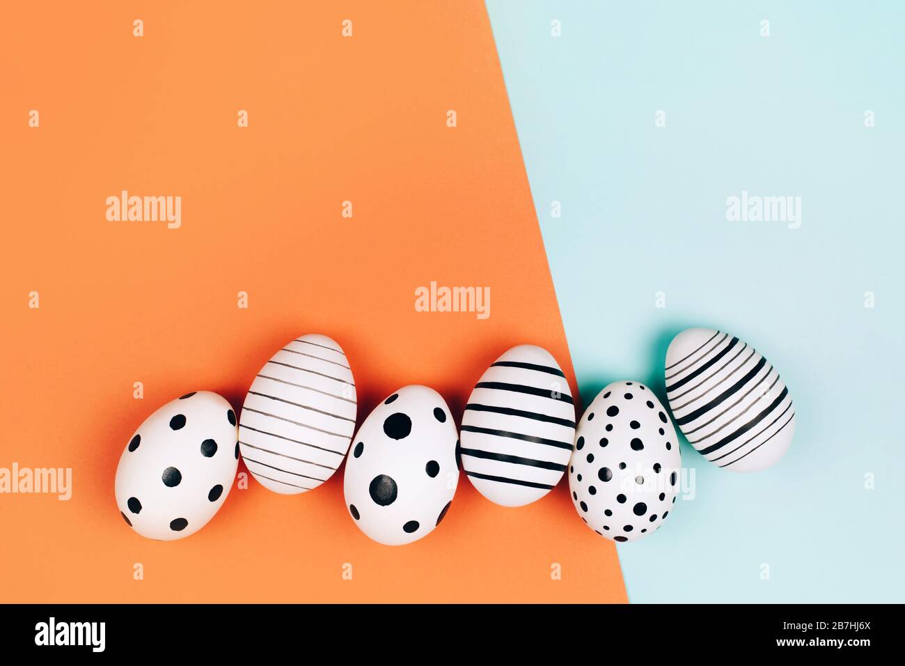 Easter eggs dotted on multicolored background. Festive concept. Flat lay style Stock Photo
