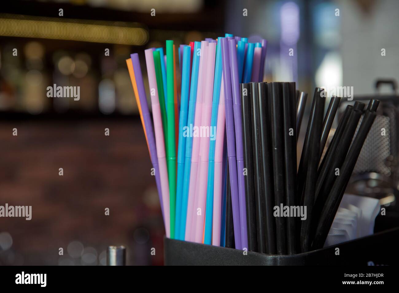 Stock photo black , blue, pink, plastic drink straws .Mixed vivid color of straw stick black background . Macro photo drink straw. Stock Photo