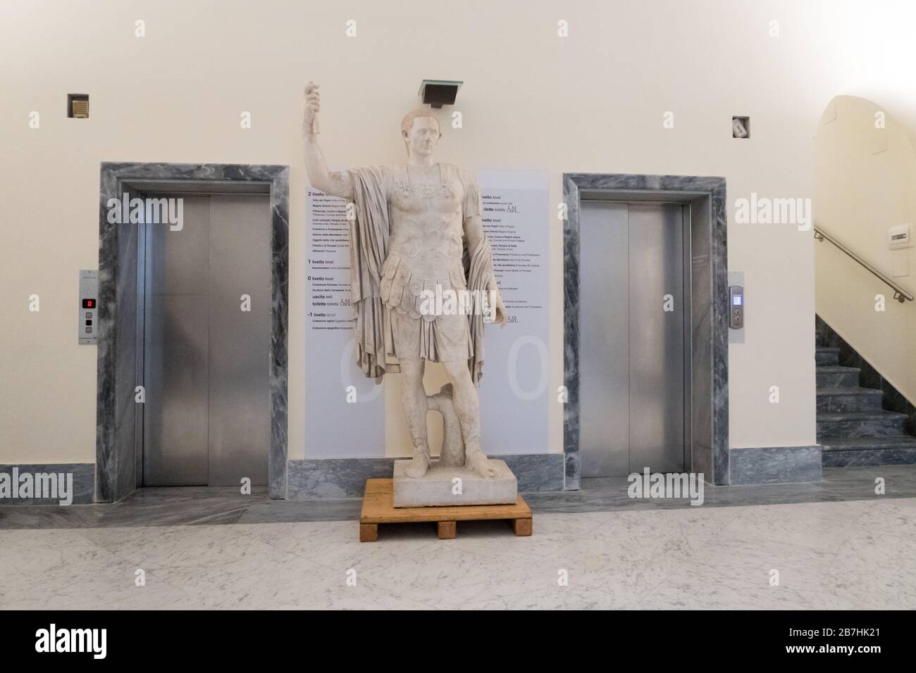 A marble statue between the doors of two elevators at the National Archeological Museum in