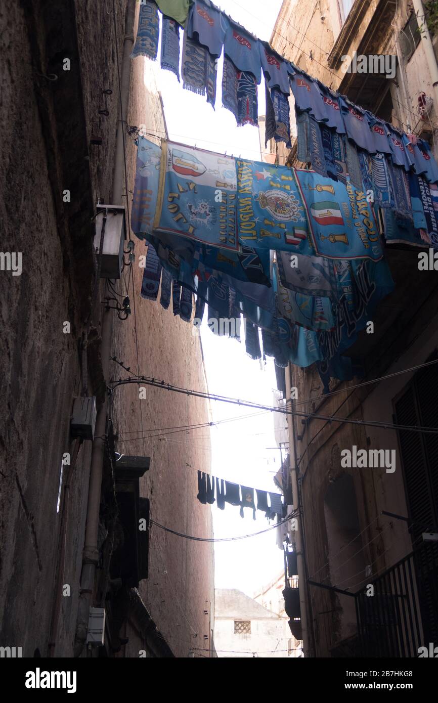 Napoli FC uniforms and scarfs are hanged outside a window in Naples city center Stock Photo