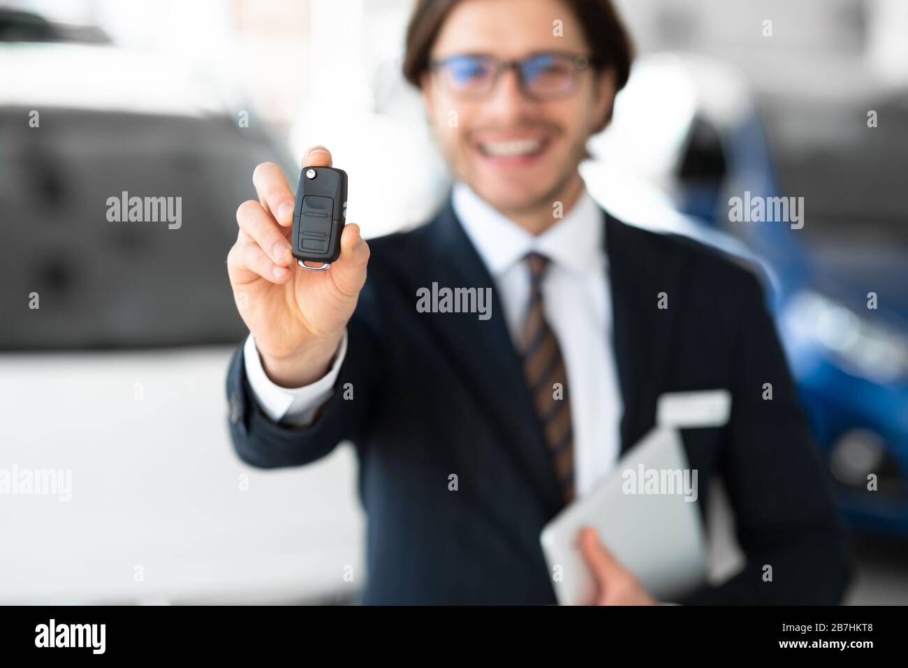 Man Showing Key Standing In Automobile Rental Office Stock Photo - Alamy