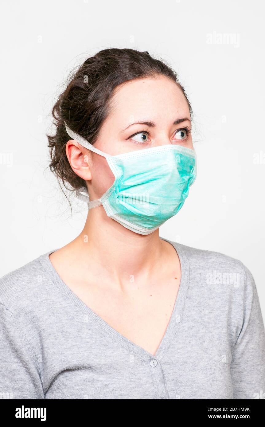 caucasian brunette woman in protective medical mask on face protection for spreading of disease virus SARS-CoV-2, Coronavirus, COVID-19. Stock Photo
