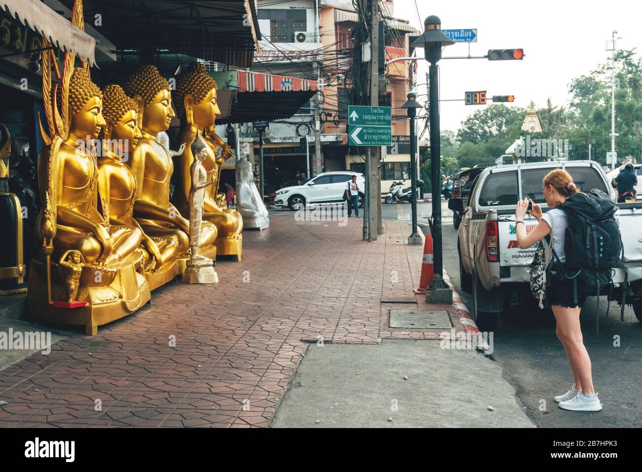 Bangkok, Thailand - January 26, 2020 : unidentified woman traveler backpacker using smartphone to taking golden Buddha statue picture at the Buddhist Stock Photo