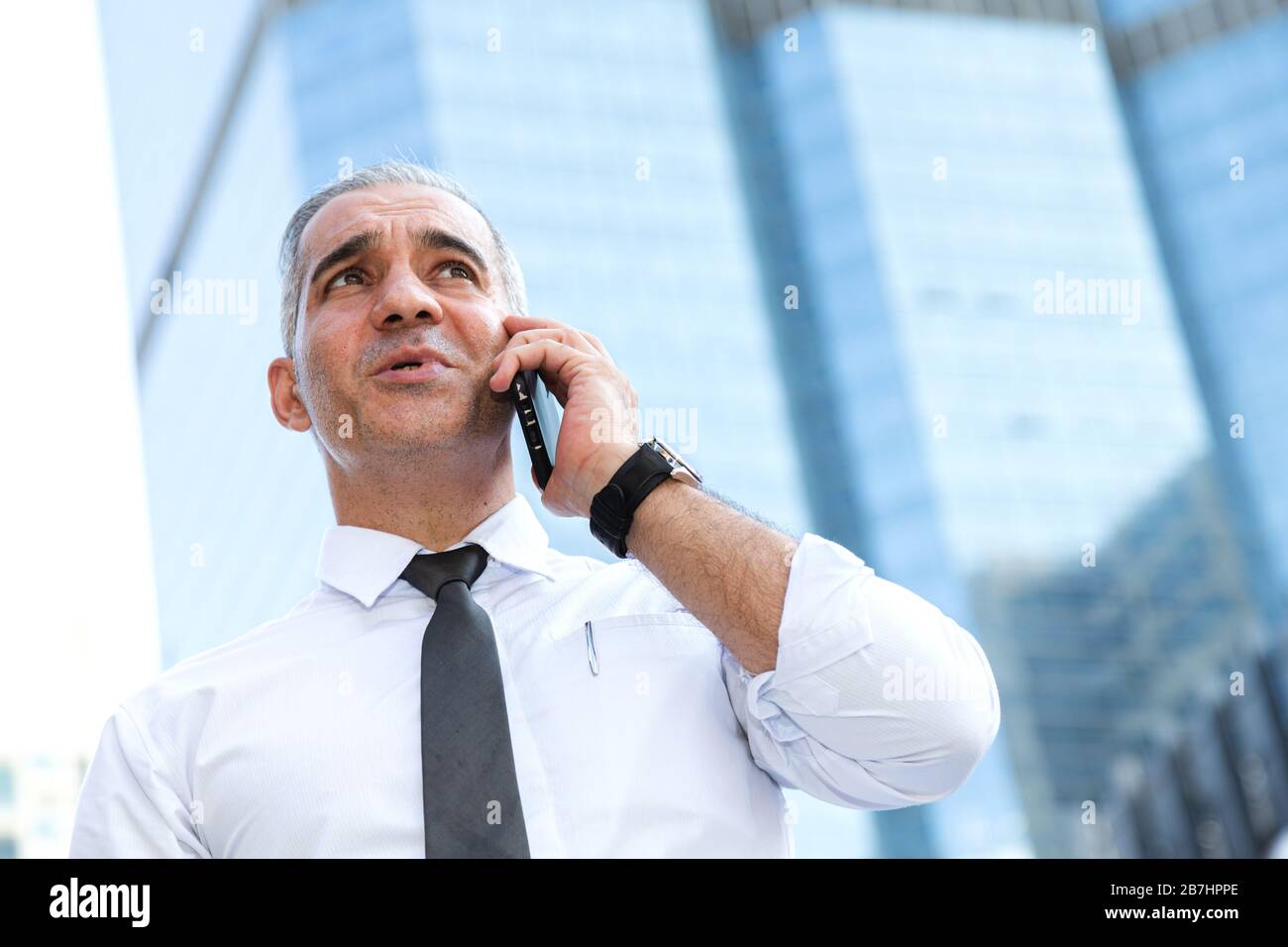 stock trader, investor, businessman talking on the mobile phone as worried about trade war news and disappointed from losing stock market after checki Stock Photo