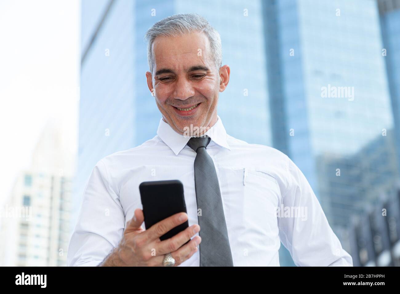 stock trader, investor, businessman happy after checking profit on investment portfolio from stock market on smartphone application at business office Stock Photo