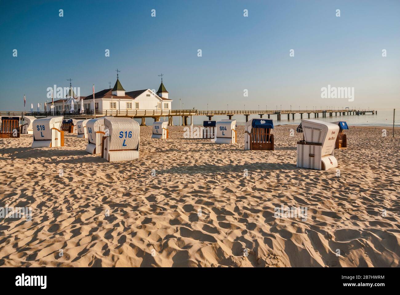 Wicker beach chairs and Seebrücke pier in Ahlbeck at Usedom Island in Mecklenburg-West Pomerania, Germany Stock Photo