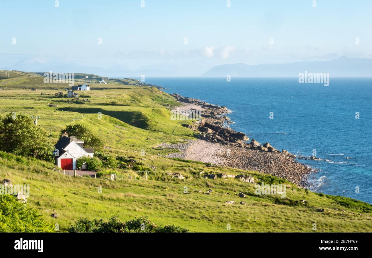 Rural Scotland coastline. The Scottish coast on the northwest of the Highlands with a view of the Isle of Skye on the misty horizon. Stock Photo