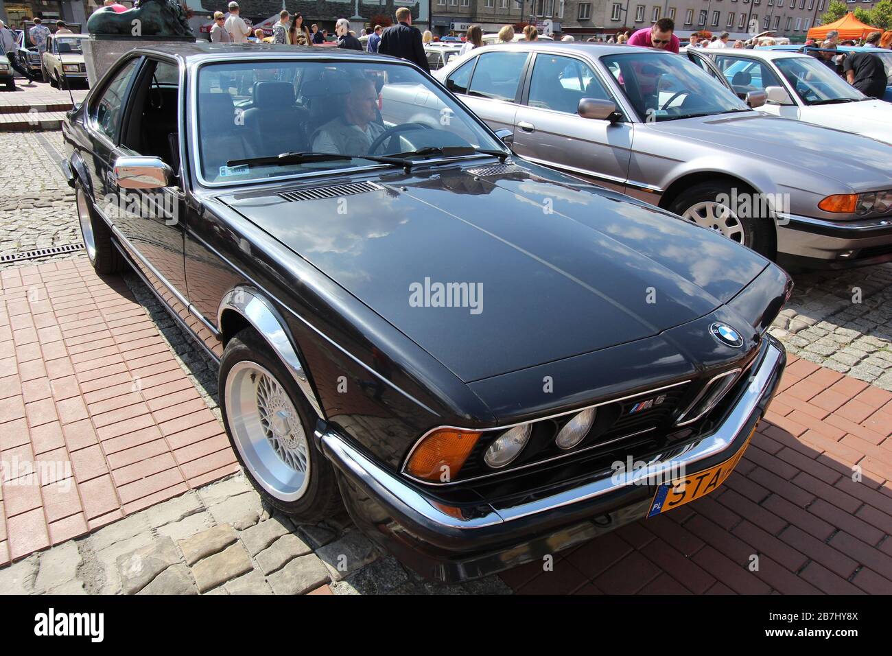 BYTOM, POLAND - SEPTEMBER 12, 2015: People walk by BMW M6 (E24) during 12th Historic Vehicle Rally in Bytom. The annual vehicle parade is one of main Stock Photo