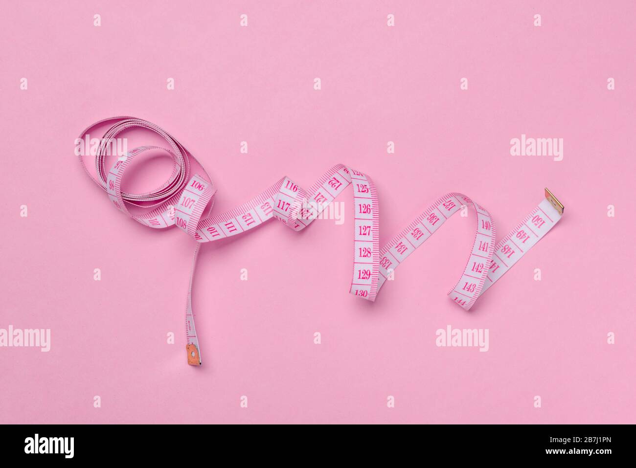 Measuring tape on pink background, top view Stock Photo - Alamy