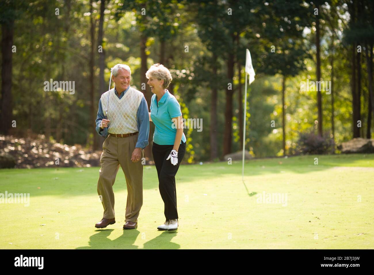 Older couple sharing a laugh on a golf course Stock Photo