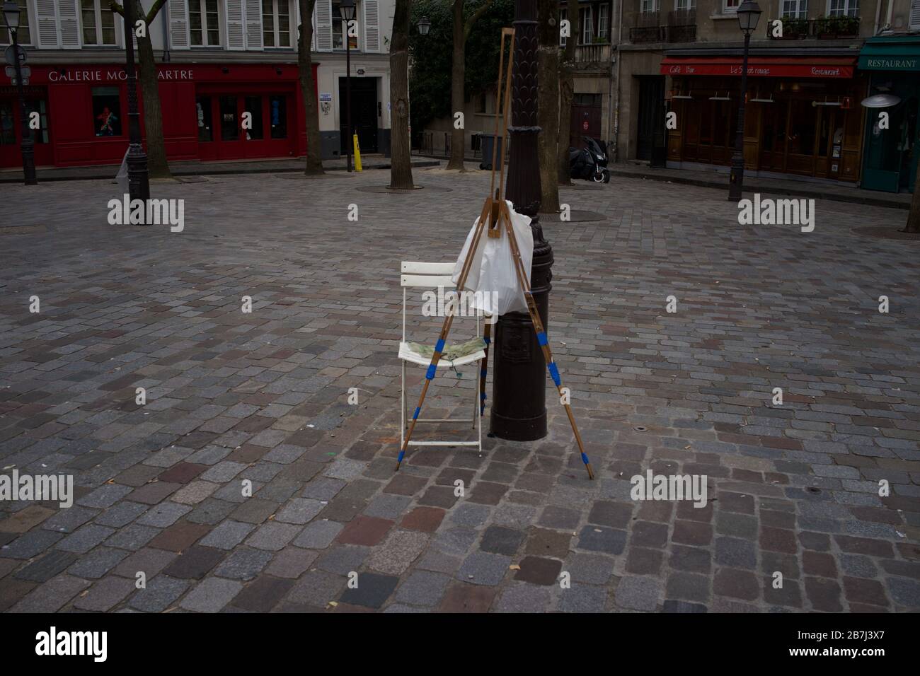 Artists easel and chair, closed cafés, a deserted Place du Tertre, 75018 Paris, France - lockdown Stock Photo