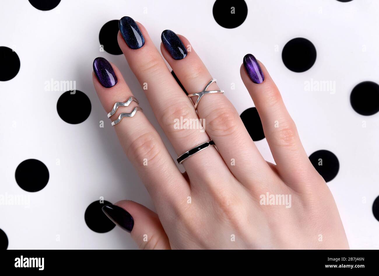 Beautiful groomed woman's hands with dark glitter polish design on nails Stock Photo