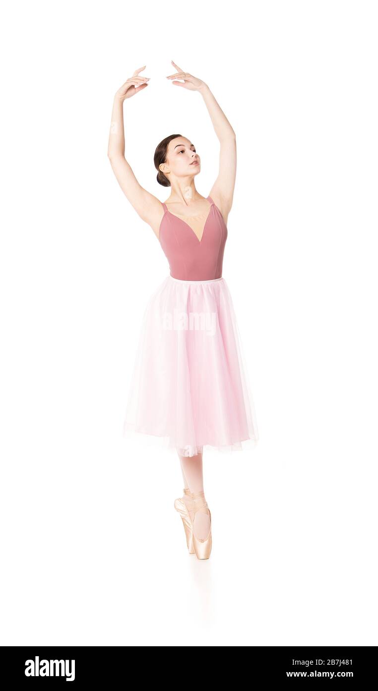 Elegant woman in a pink skirt and beige top dancing ballet. Studio ...