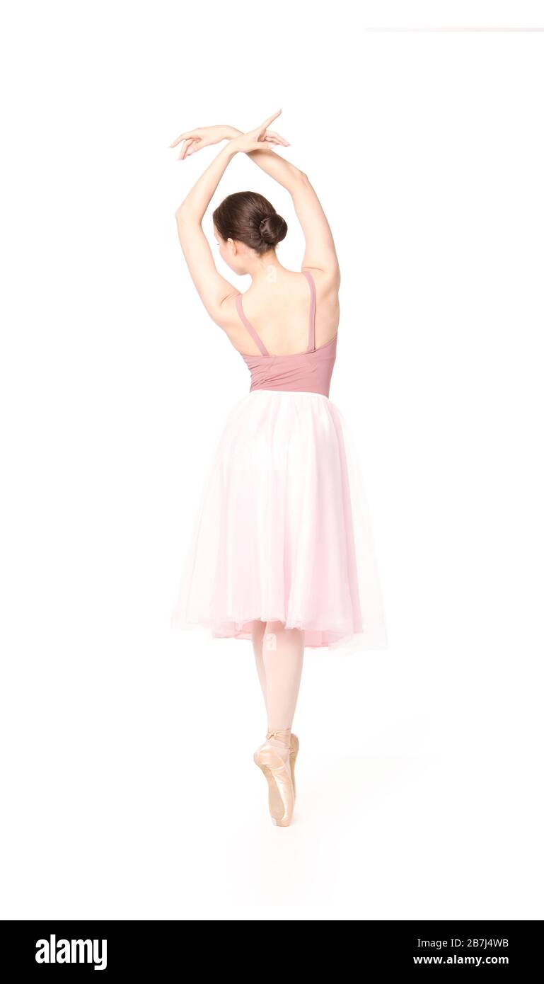 Elegant woman in a pink skirt and beige top dancing ballet. Studio ...