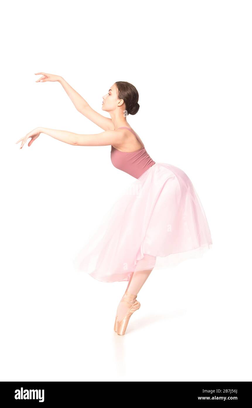 Elegant woman in a pink skirt and beige top dancing ballet. Studio ...