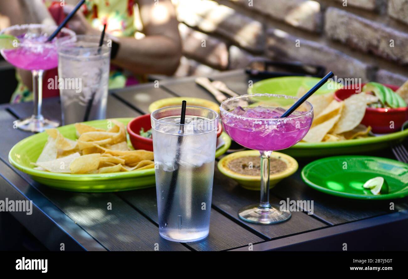 Rim salted, Hot pink cocktails accent the chips and salsa in colorful dishes on patio table at trendy Mexican restaurant in Scottsdale, AZ, Stock Photo