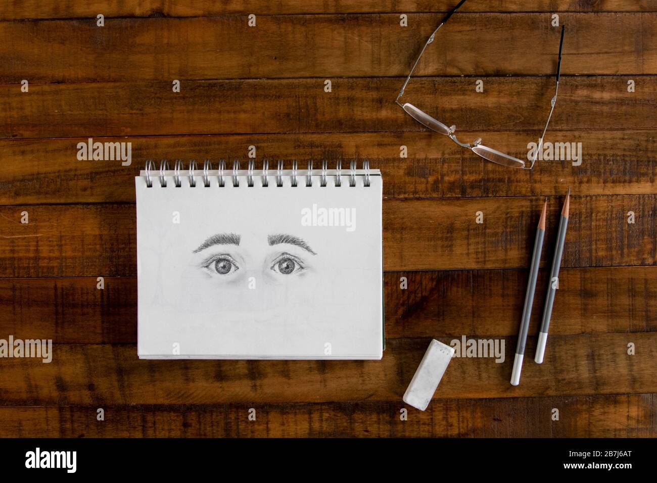 Sketch pad with graphite drawing of eyes Stock Photo