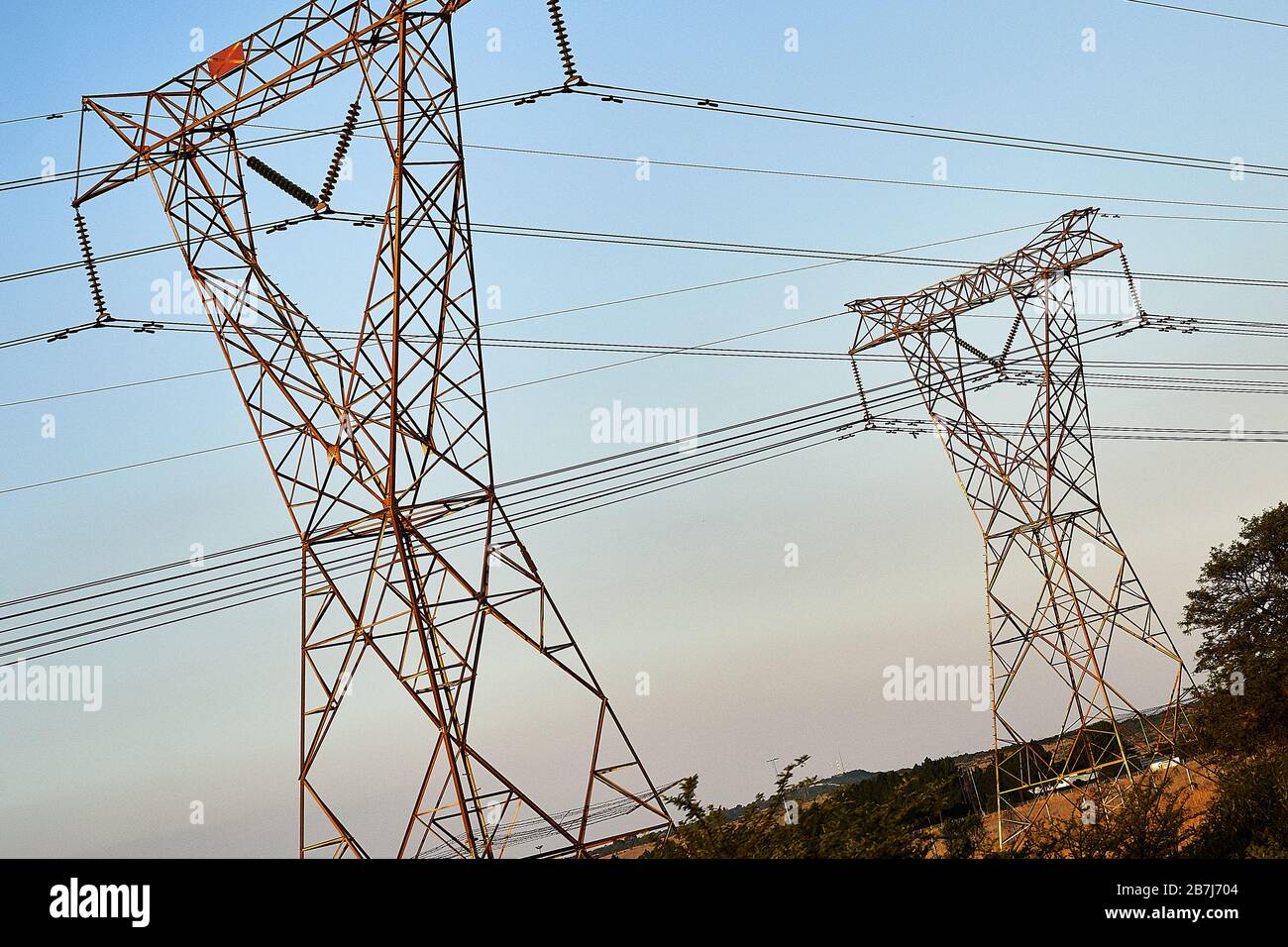 Electrical pylons in South Africa while sun sets, surrounding of