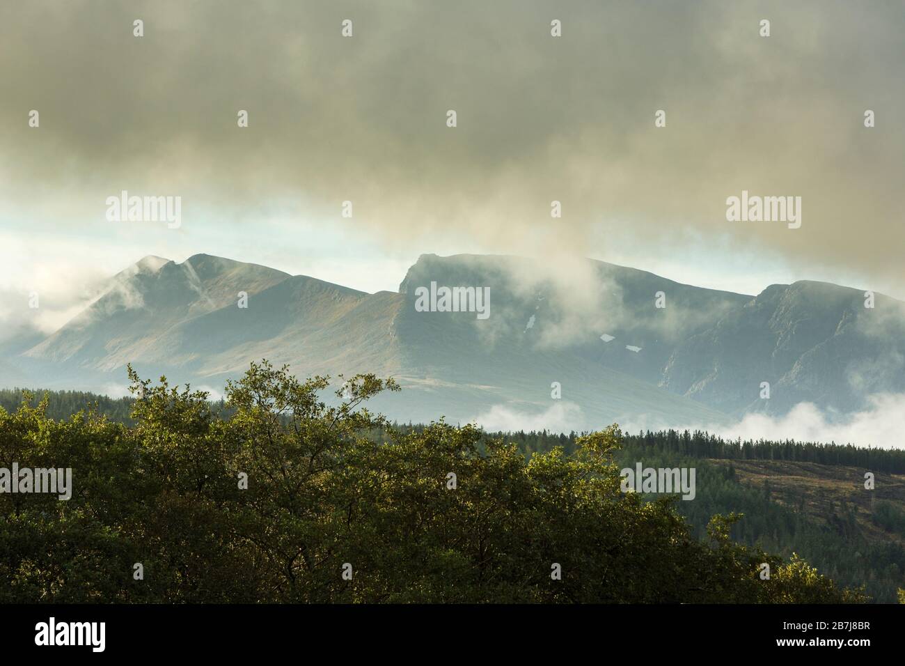 Low Cloud and Drifting Mists over Carn Mor Dearg and the North Face of Ben Nevis, with pockets of snow, seen from the Great Glen Way, Scotland, UK Stock Photo