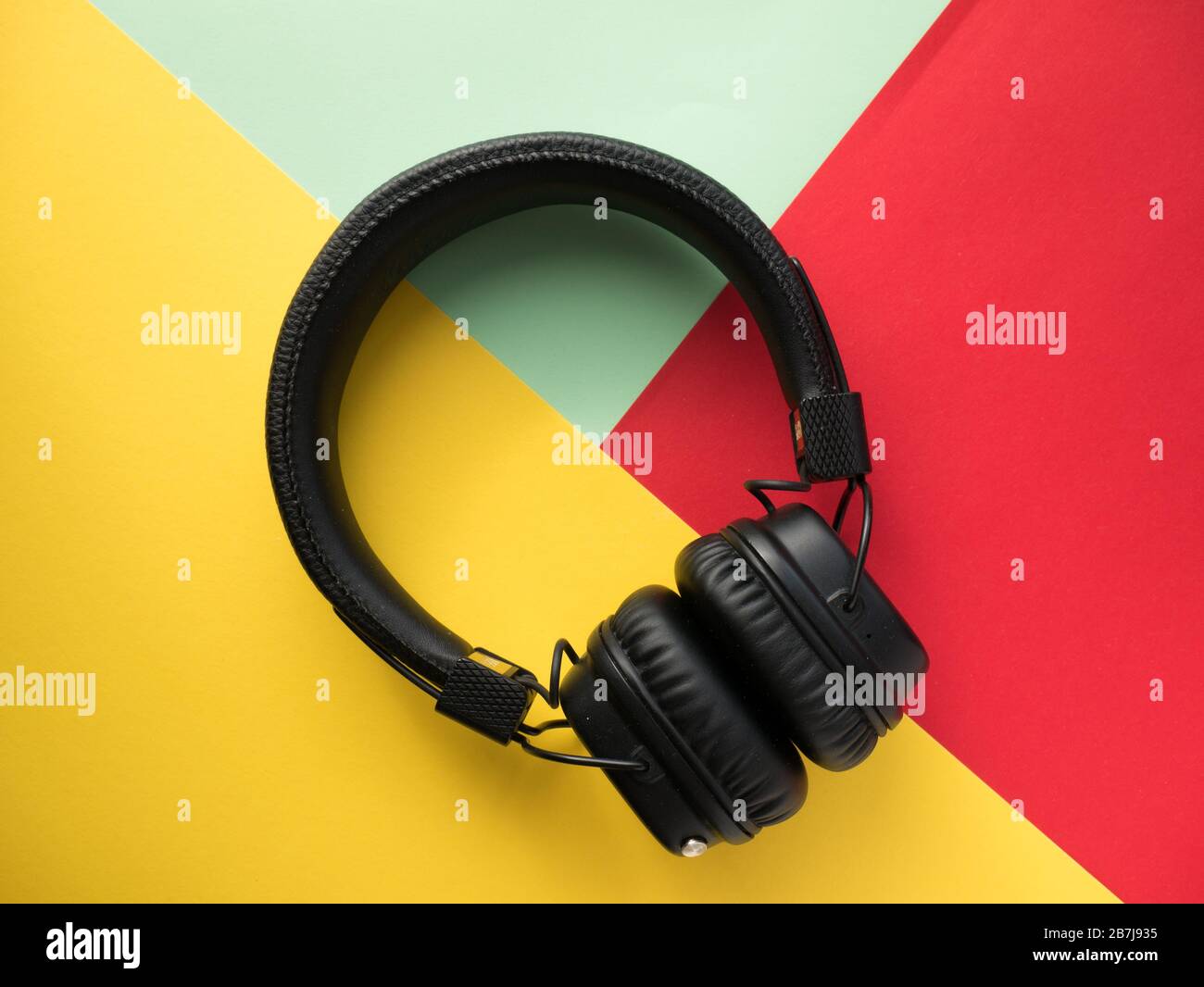 Classic black wireless headphones on colored paper background. Retro style.  80s. Pop culture. Top view Stock Photo - Alamy