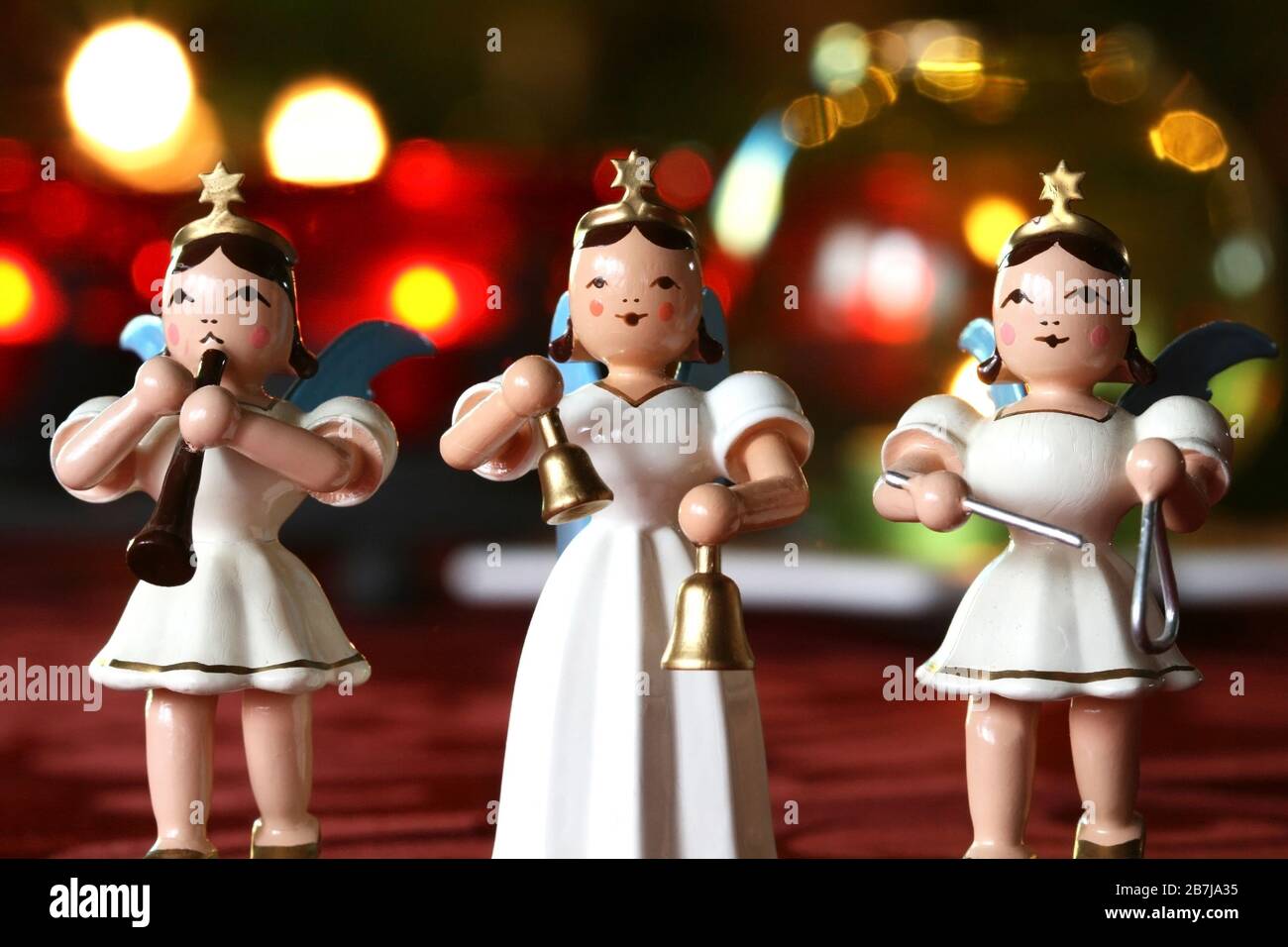 Christmas Concert: three decoration angels making music in front of Christmassy lights Stock Photo