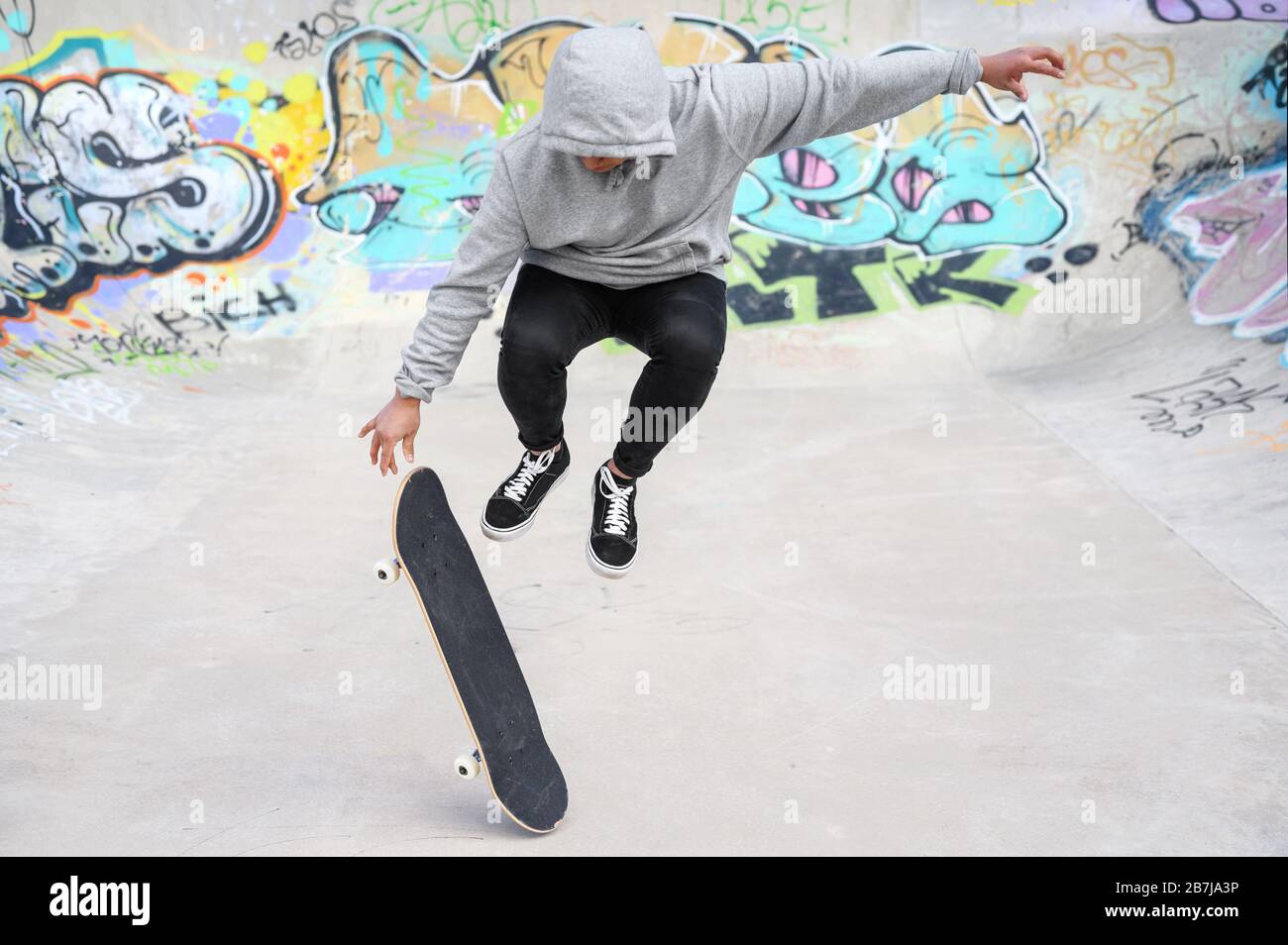 young skater doing jump trick at skate park . Stock Photo