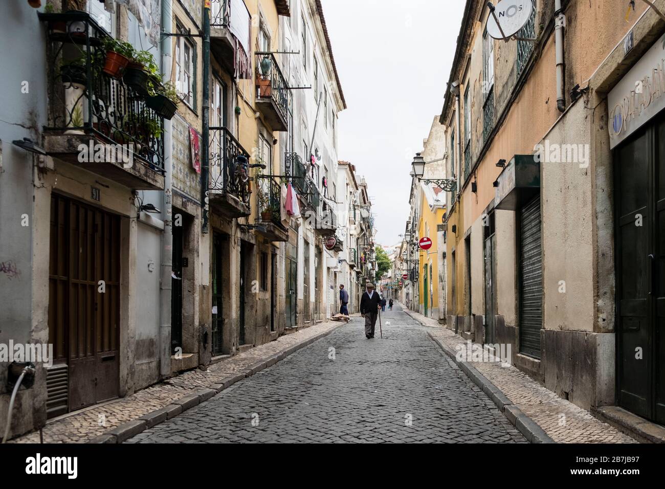 Older Portuguese man walking on a cobblestone street in the Bairro Alto ...