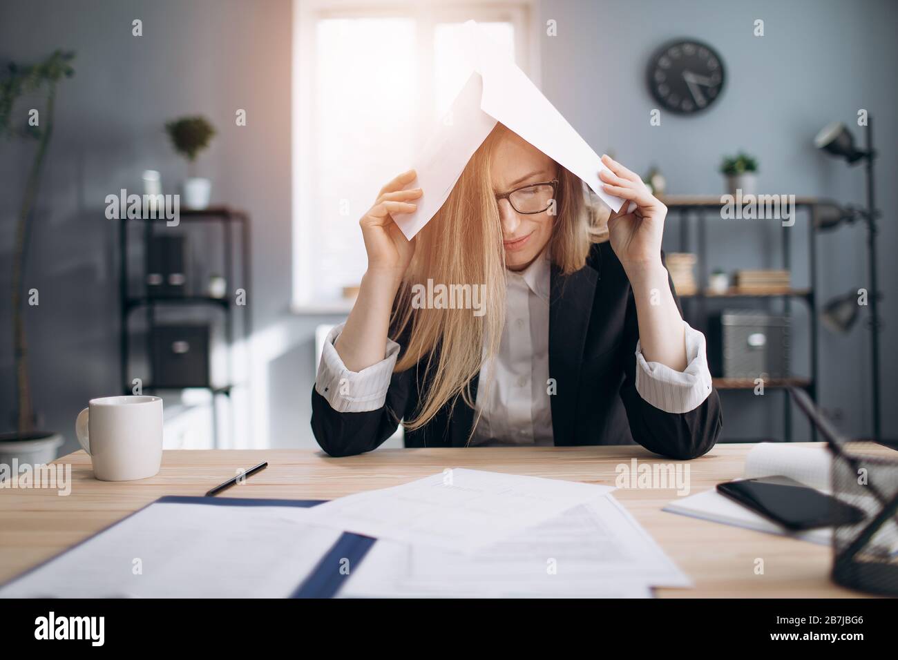 Tired lady stressing while working with paper documents Stock Photo