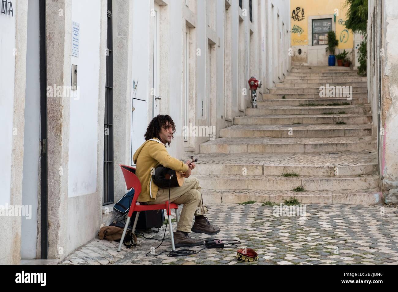 Street musician in Alfama district, playing traditional Portuguese fado guitar, Lisbon, Portugal Stock Photo