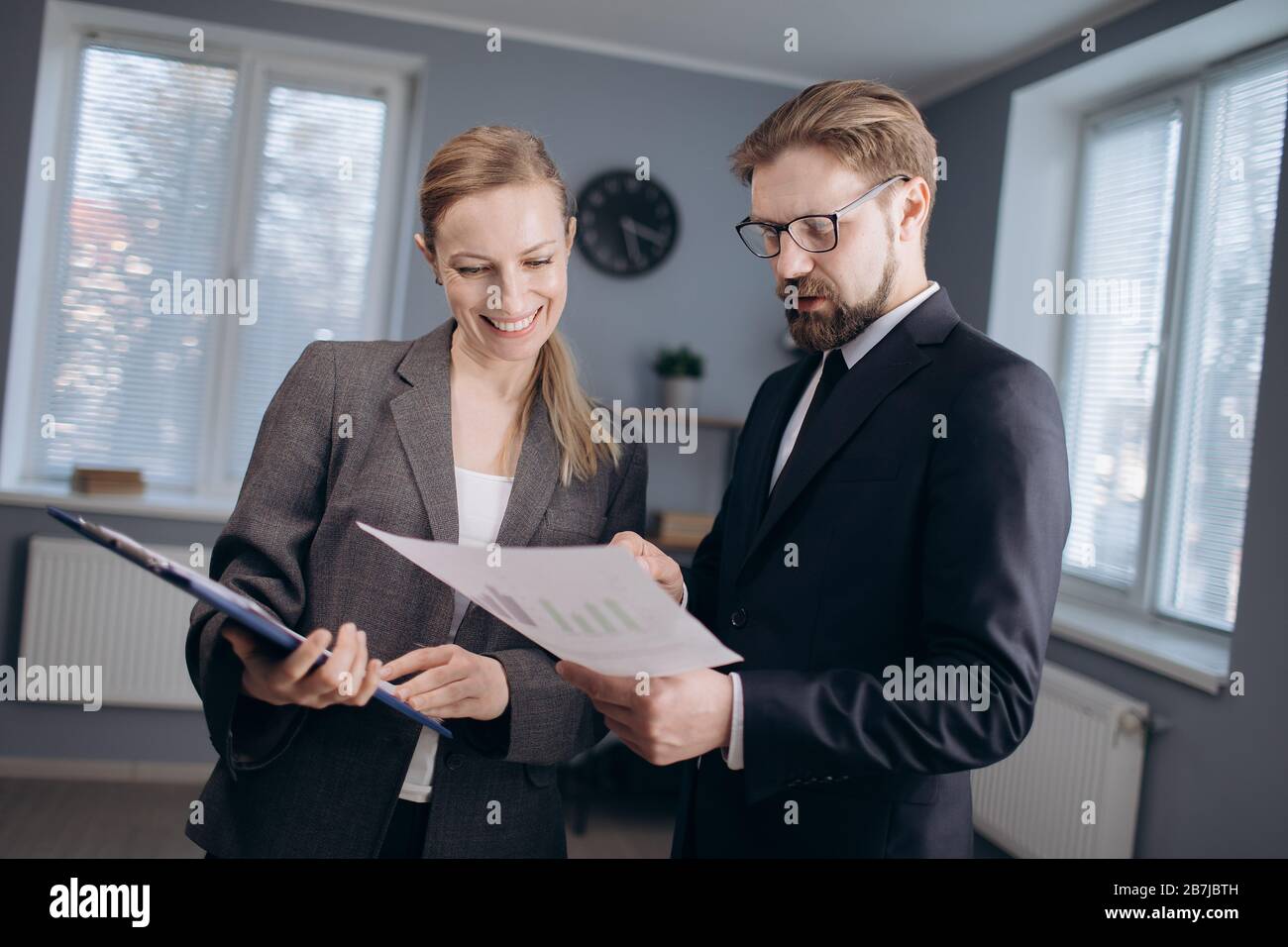 Business partners standing in office with documents Stock Photo
