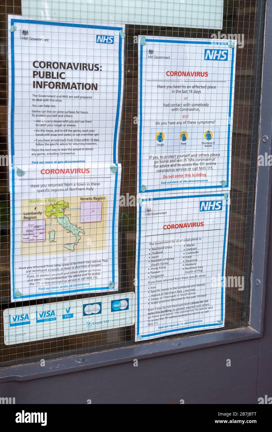 National Health Service NHS government information Coronavirus notice glass door entrance to GP surgery, Alderton, Suffolk, England, UK, -15 March 2020 Stock Photo