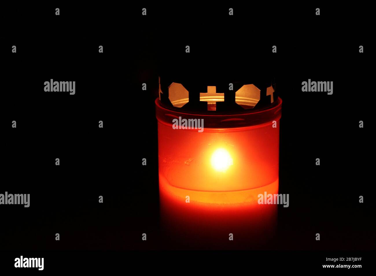 All Saints' Day: votive candle on All Saints' Day shining warm out of the dark Stock Photo