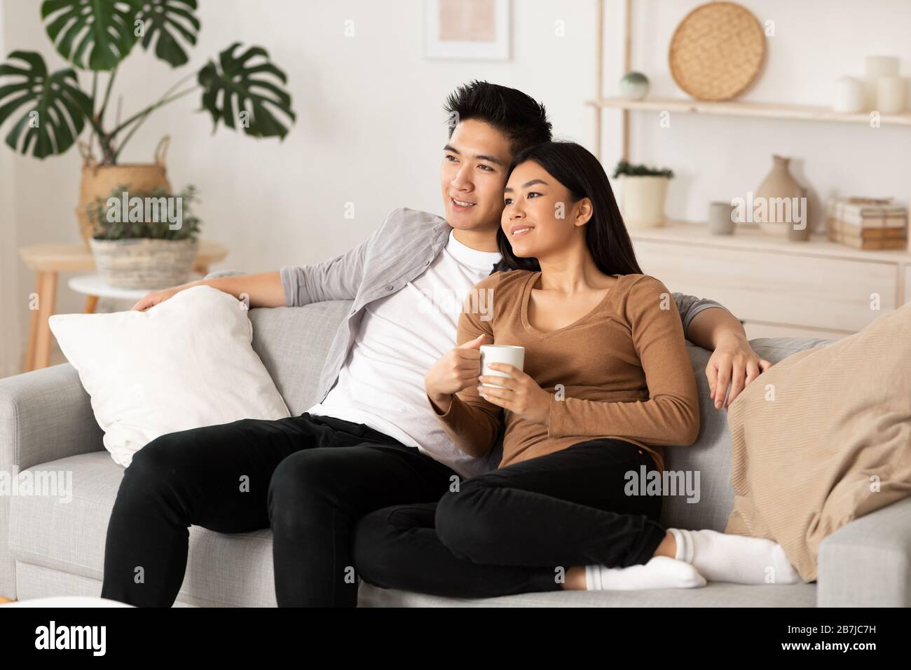 Korean couple resting at home and watching tv Stock Photo