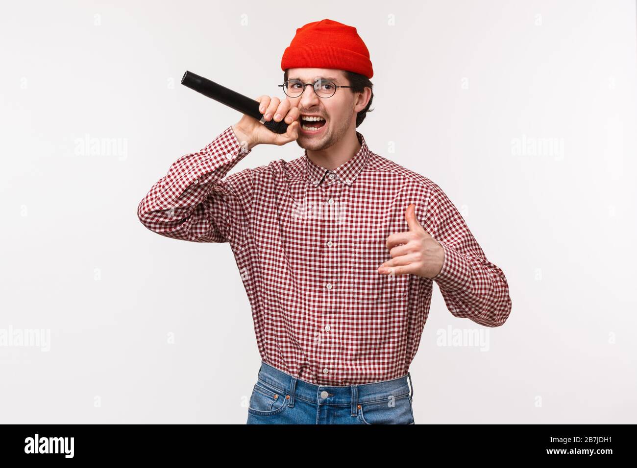Funny and passionate cool hipster guy in red beanie and glasses singing rap song acting excited, holding microphone, having fun at karaoke with friend Stock Photo - Alamy Funny and passionate cool hipster guy in red beanie and glasses singing rap song acting excited, holding microphone, having fun at karaoke with friend Stock Photo - Alamy