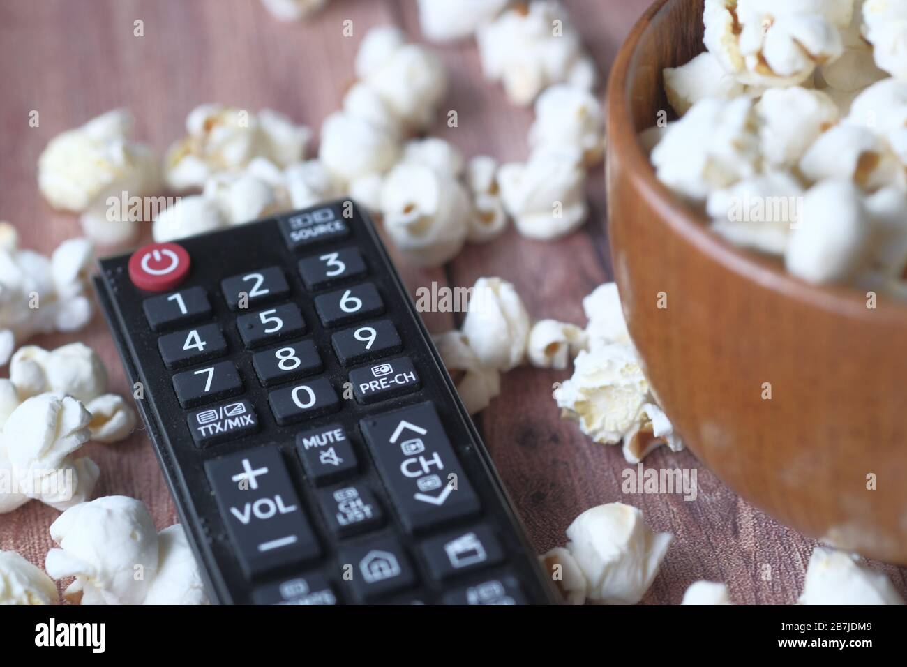 Close up of tv remote and popcorn on table  Stock Photo